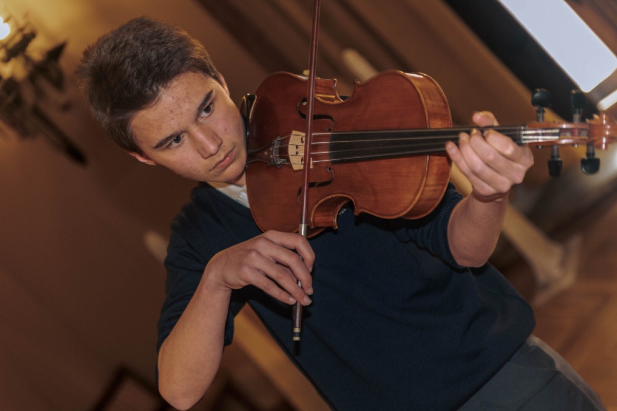 niño tocando violín en su Bachillerato de Artes Musicales